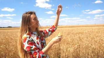 young beautiful girl laughs and puts bubbles in the field in slow motion video