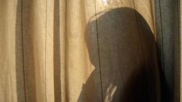 Silhouette Mädchen hinter dem warmen Vorhang video