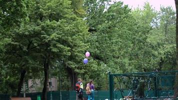 los jóvenes van a la calle y llevan globos de mano. video