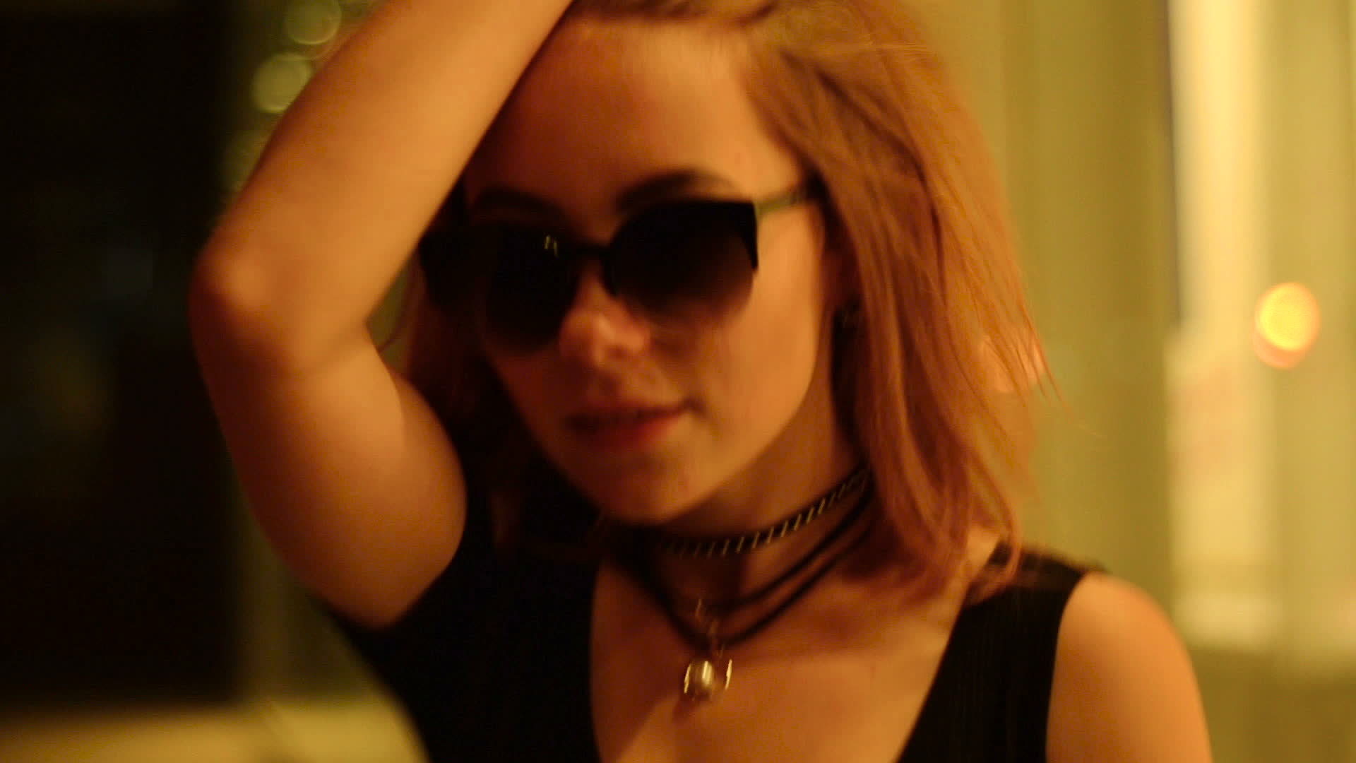 young beautiful woman adjusts her arm hair looks at the camera and goes