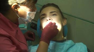 young girl treats teeth with a dentist video