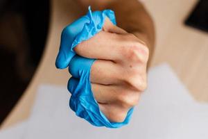 Hand wearing torn plastic protective glove photo