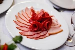 bandeja de comida con deliciosos trozos de salami en rodajas foto