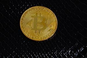 Golden bitcoins on black leather background photo