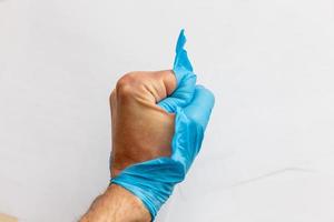 Hand wearing torn plastic protective glove photo