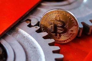 engranajes y cogs de cerca y moneda bitcoin foto