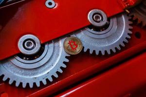 Gears and cogs close up and bitcoin coin photo