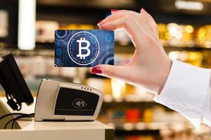 Woman's Hand holding credit bank card to buy bitcoin and block chain photo