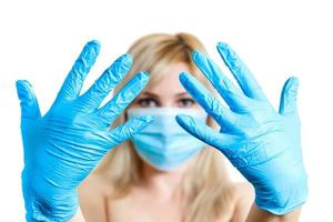 Beauty treatment of the young beautiful female face doctor s hand in gloves touch face