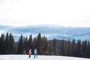 Portrait of smiling couple on skis in the mountains photo