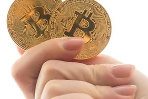 Two golden bitcoin in  hand digitall symbol of a new virtual currency isolated on white photo