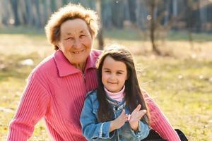 Grandmother with granddaughter in park, spring photo