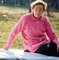 Alone old woman sitting in the park photo