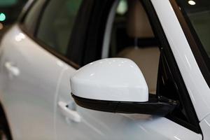 Close up of a wing mirror of white car photo