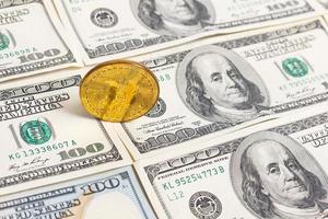 Golden bitcoin coin on us dollars close up