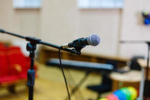 Microphone over the abstract blurred of conference hall or seminar room background photo