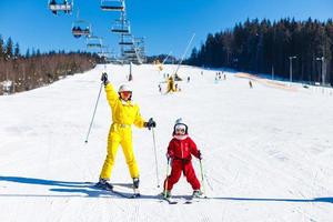 mother and daughter in bright winter ski suits photo