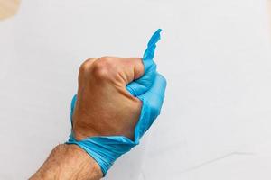 Hand wearing torn plastic protective glove photo
