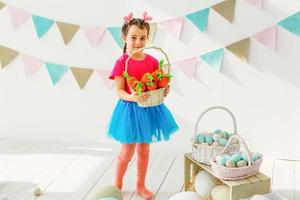 Cute little girl with bunny ears and basket of Easter eggs photo