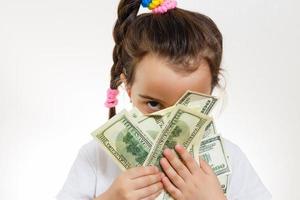 niño feliz con dinero en dólares aislado en un fondo blanco foto