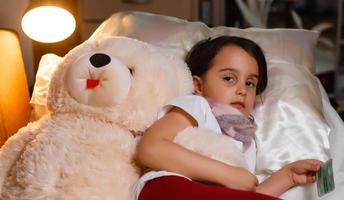 Little girl with illness on the bed photo