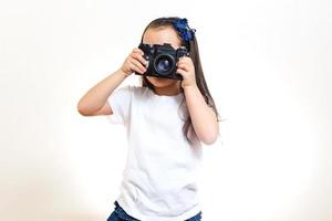 chica tomando una foto con una cámara retro profesional aislada en blanco