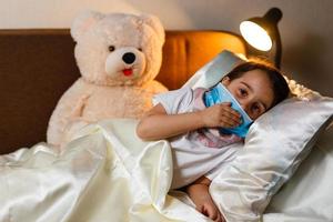 Little girl with fever in the bed photo