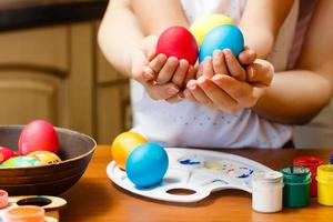 mother and little daughter painting eggs, easter photo