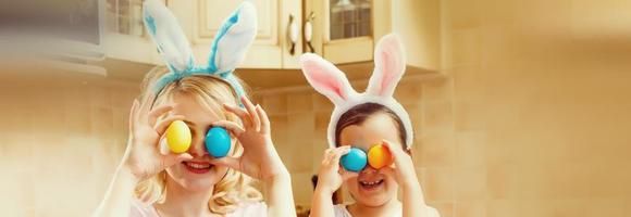 Happy easter A mother and her daughter painting Easter eggs. Happy family preparing for Easter. Cute little child girl wearing bunny ears on Easter day. photo