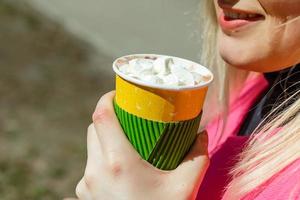 Female hands holding hot chocolate with cream. Top view. photo