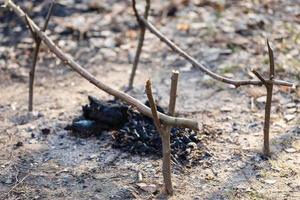 Firewood in the forest on earth burn. Fireplace for barbecue. Shish kebabs. View from above. photo