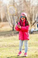 niña de rojo jugando al bádminton al aire libre foto