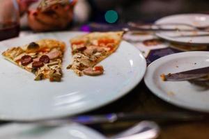 plato con una rebanada de pizza en una mesa de madera foto