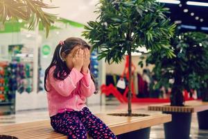 adorable niña está llorando en el centro comercial