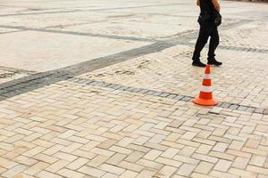 Red and white witches hat cone traffic sign barrier applying on busy street downtown photo