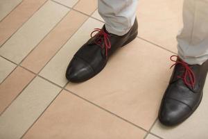 Young fashion man's legs in brown boots on floor photo