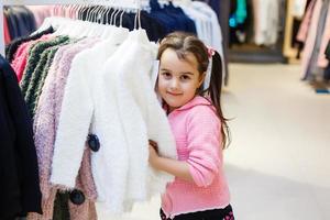 Adorable little girl choosing clothes photo