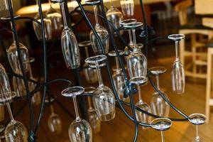 los vasos están perfectamente limpios colgados en la barra del bar. resplandecientes luces cálidas. foto