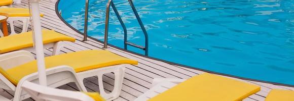 swimming pool with yellows sun lounger photo