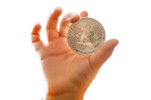 Golden bitcoin in a child hand digitall symbol of a new virtual currency selective focus photo