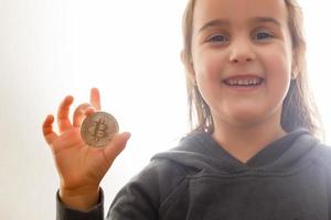 Golden bitcoin in a child hand digitall symbol of a new virtual currency selective focus photo