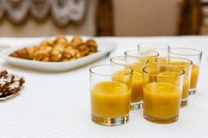 Many shot glasses with alcohol and citrus fruits juice photo