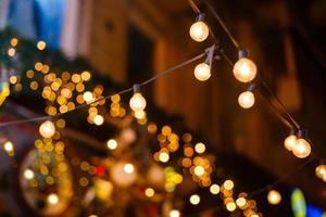 Garlands of lamps on a wooden stand on the street. A wedding Banquet. photo