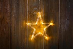 Bright Christmas garland of stars on a wooden wall photo