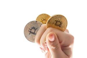 hand holds three coins of digital currency bitcoin photo