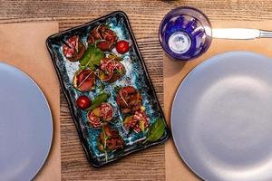 panecillos horneados con salami en forma de rosas sobre la mesa. vista superior horizontal foto