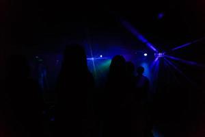 Nightlife and disco concept. Young people are dancing in club photo