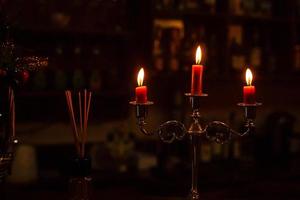 Old candlestick holder in front of a dark red background photo