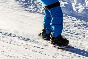 Snowboarder doing a toe side carve with deep blue sky in background photo