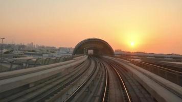 dubai, uae, 2022 - u-bahnzug auf eisenbahn in dubai mit museum der zukunft und futuristischem gebäudehintergrund. fpv pov bei schneller Antriebsbewegung. Fahrerlose U-Bahn video